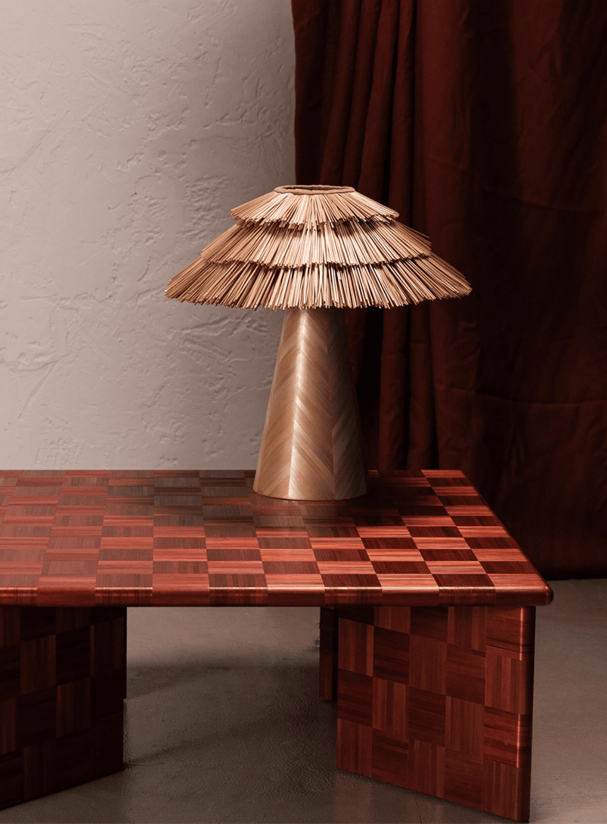 Boho table lamp standing on a red checkered table beside a curtain