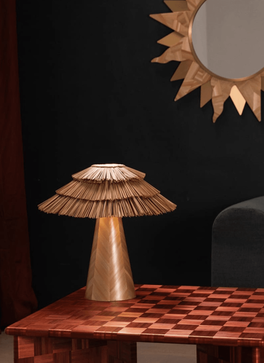 Boho table lamp on a red checkered table beside a sunburst mirror