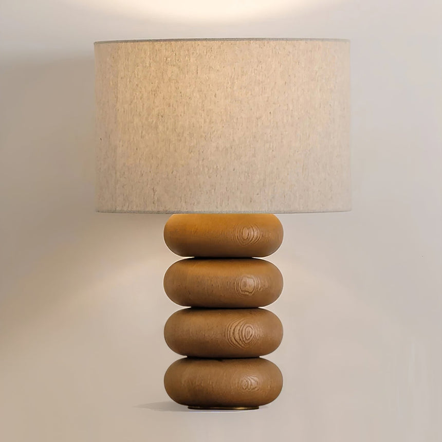 Close view of the lit linen drum above three flattened wood spheres