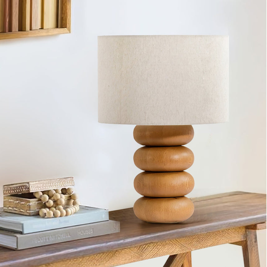 Stacked sphere table lamp on a console beside books and small objects