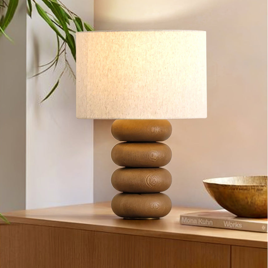 Stacked sphere table lamp lit beside a shallow brass bowl on a sideboard