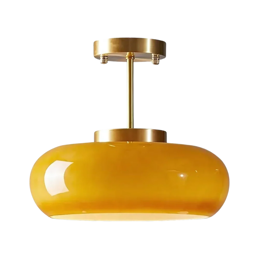 The yellow glass dome on its brass stem shown against a pale background