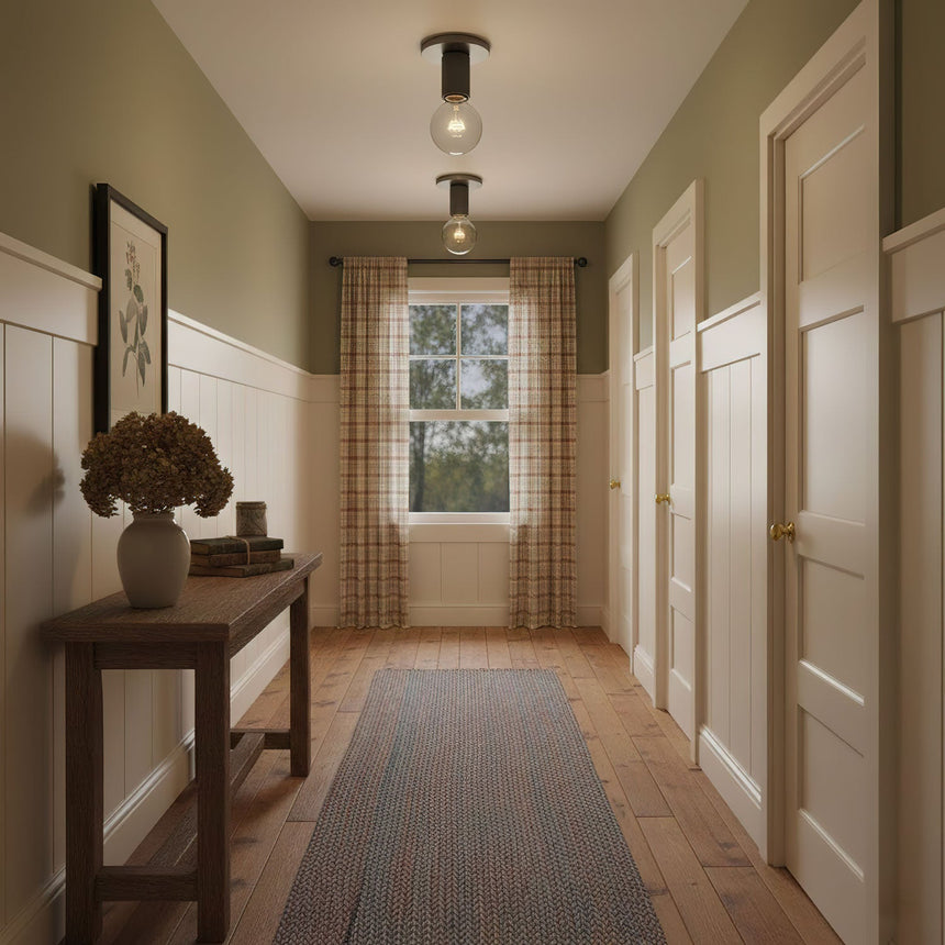 Black ceiling lights in a corridor with olive walls and a dark wood floor