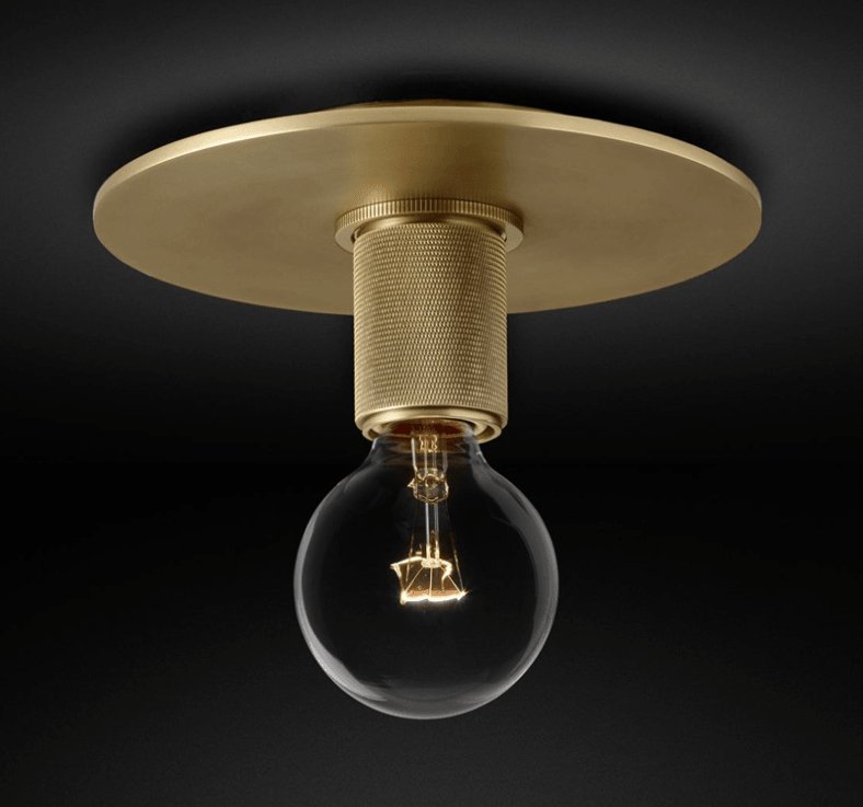 Brass ceiling light with a globe shade seen from below against a dark backdrop