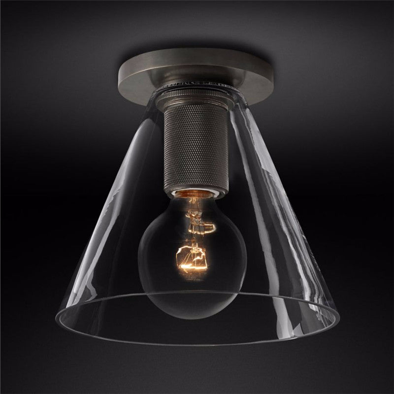Black ceiling light with a clear cone shade against a dark backdrop