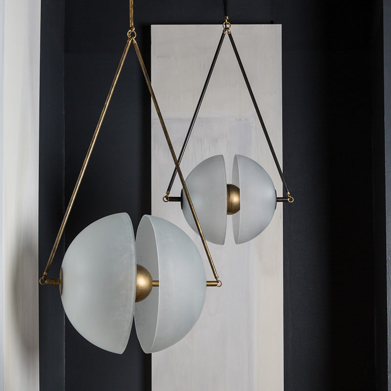 The brass frame and split glass disc lit against a dark painted wall