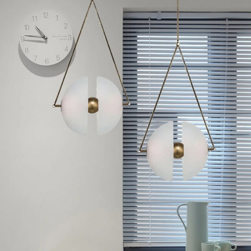 Two framed glass discs lit on a pale wall beside a round clock