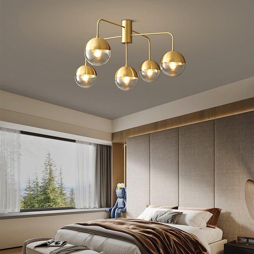 Five globe brass ceiling light above a bed beside a wide window
