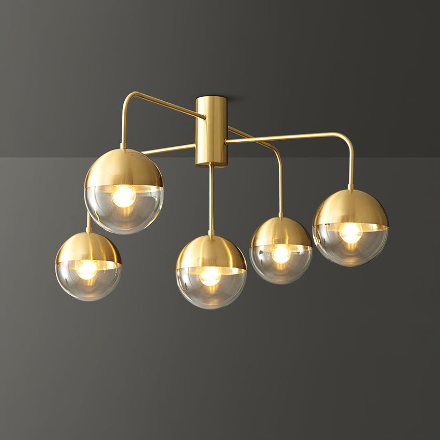 Five globe brass ceiling light seen at an angle against a gray background