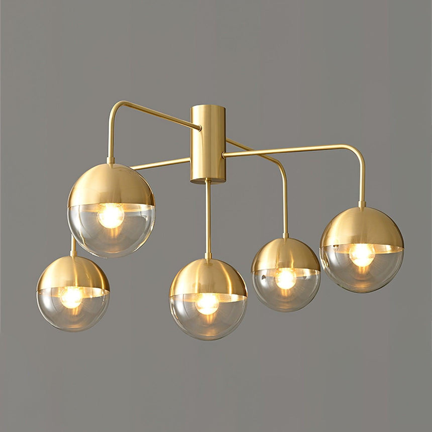 Five globe brass ceiling light with the globes unlit on a gray backdrop