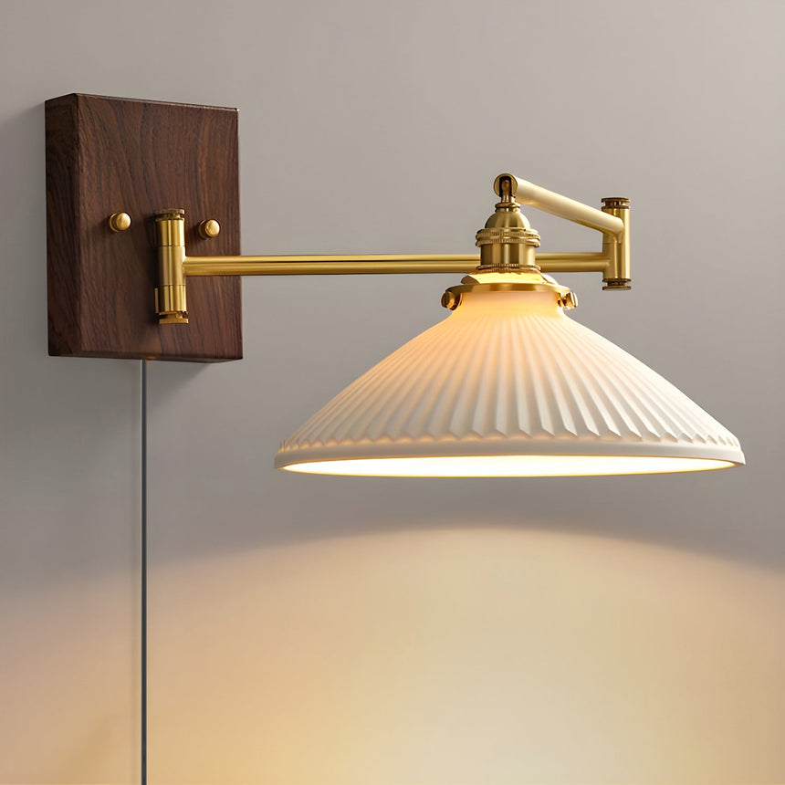 Wide ribbed ceramic dome lit on a brass arm, the cord hanging down