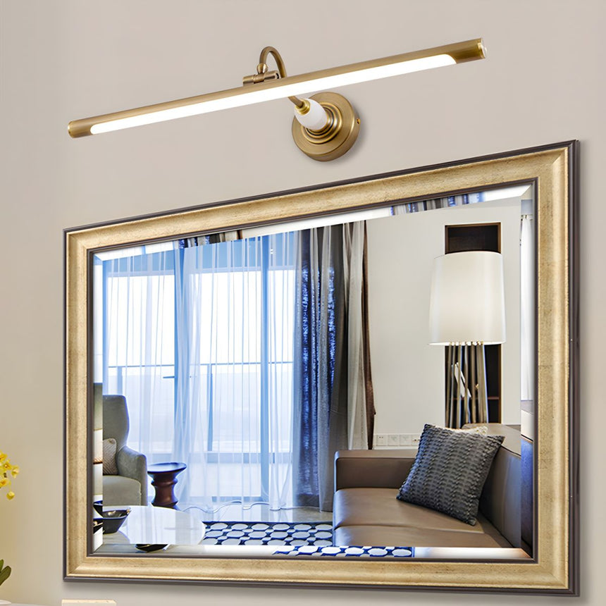 Brass bar lit above a gilt framed mirror reflecting a curtained window and a lamp