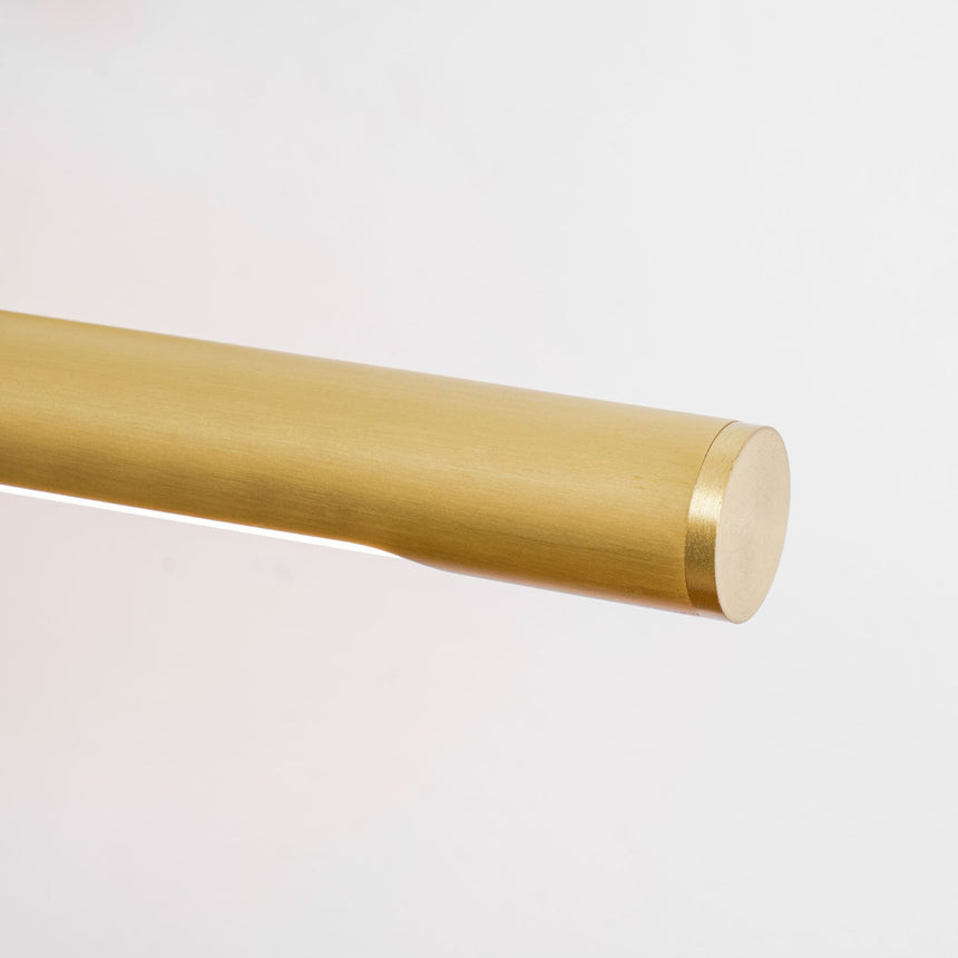 Close view of the tube end, a plain rounded cap on a warm metal cylinder
