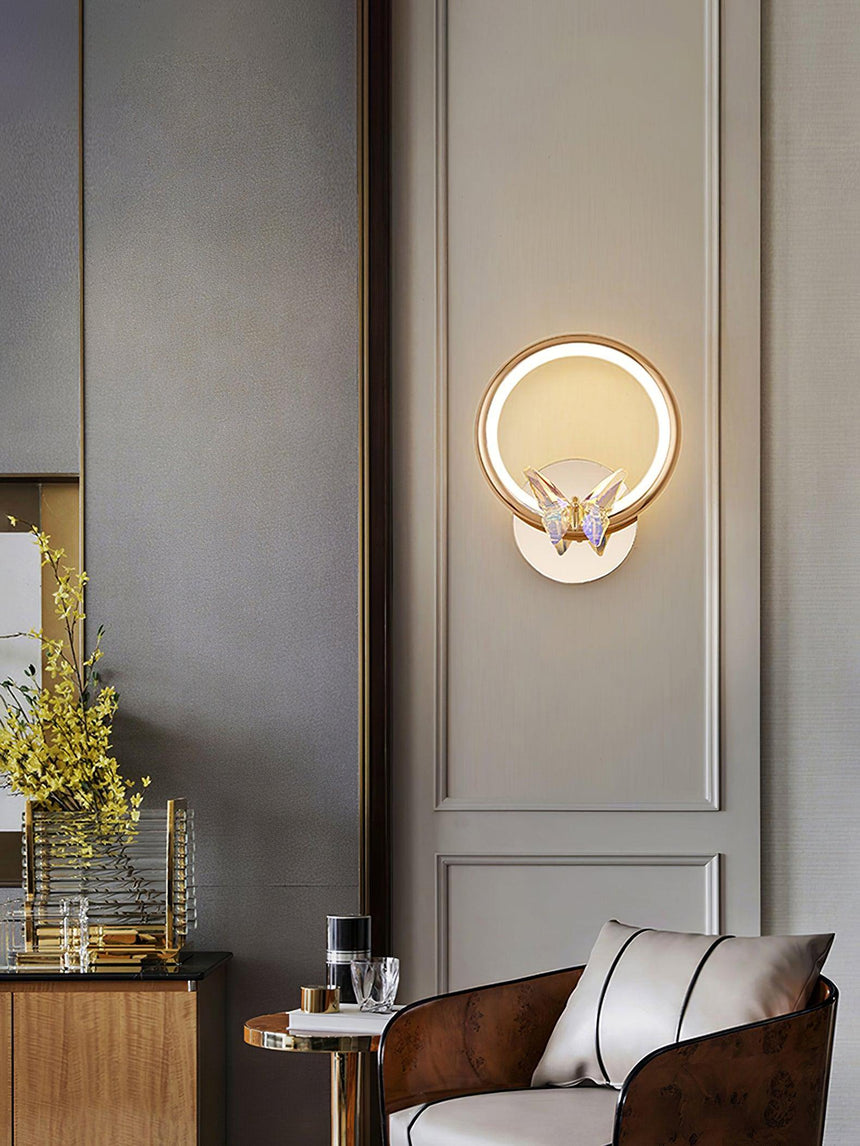 The butterfly ring lit on a gray paneled wall above a leather armchair