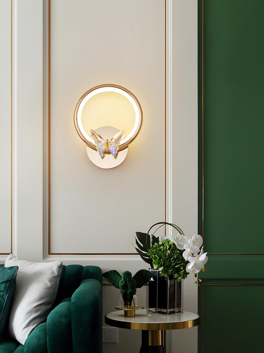 The butterfly ring on a paneled wall above a green velvet sofa and a side table