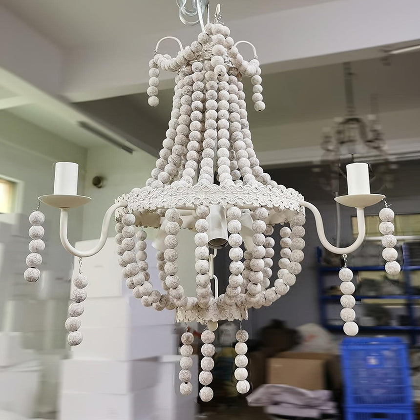 The bead swags and the nine candle arms seen close, the frame photographed in a store room