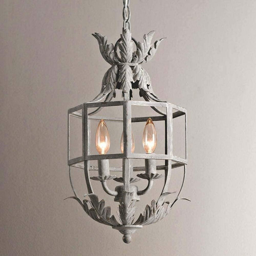 The cage lit against a pale wall, three candle lamps burning inside the frame