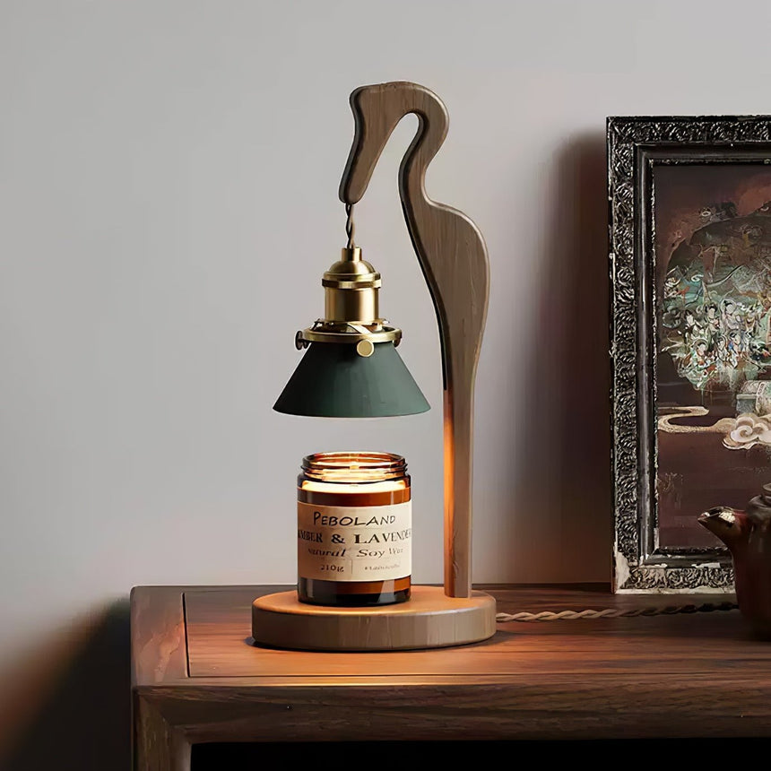 Heron lamp lit on a table beside a gilt framed picture and a mirror