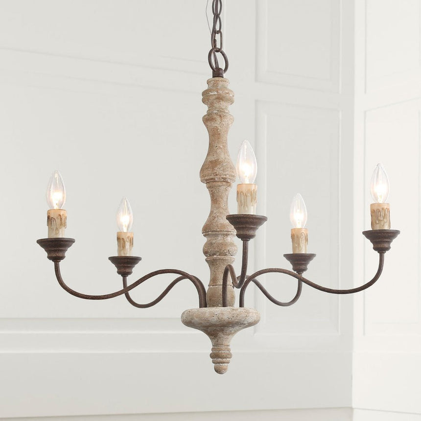 The five candle bulbs lit against a paneled white wall, the wood column reading pale gray