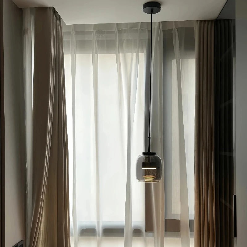 Single glass shade in a room with long curtains
