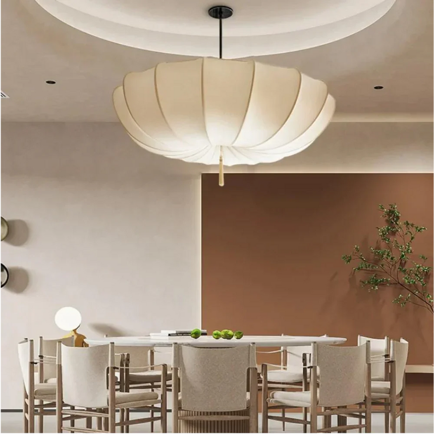 Scalloped cloth shade above a dining table with wooden chairs