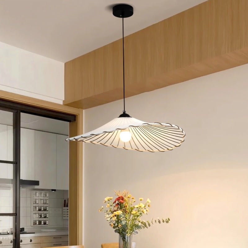 The two tier shade above a round dining table with a tall plant behind it