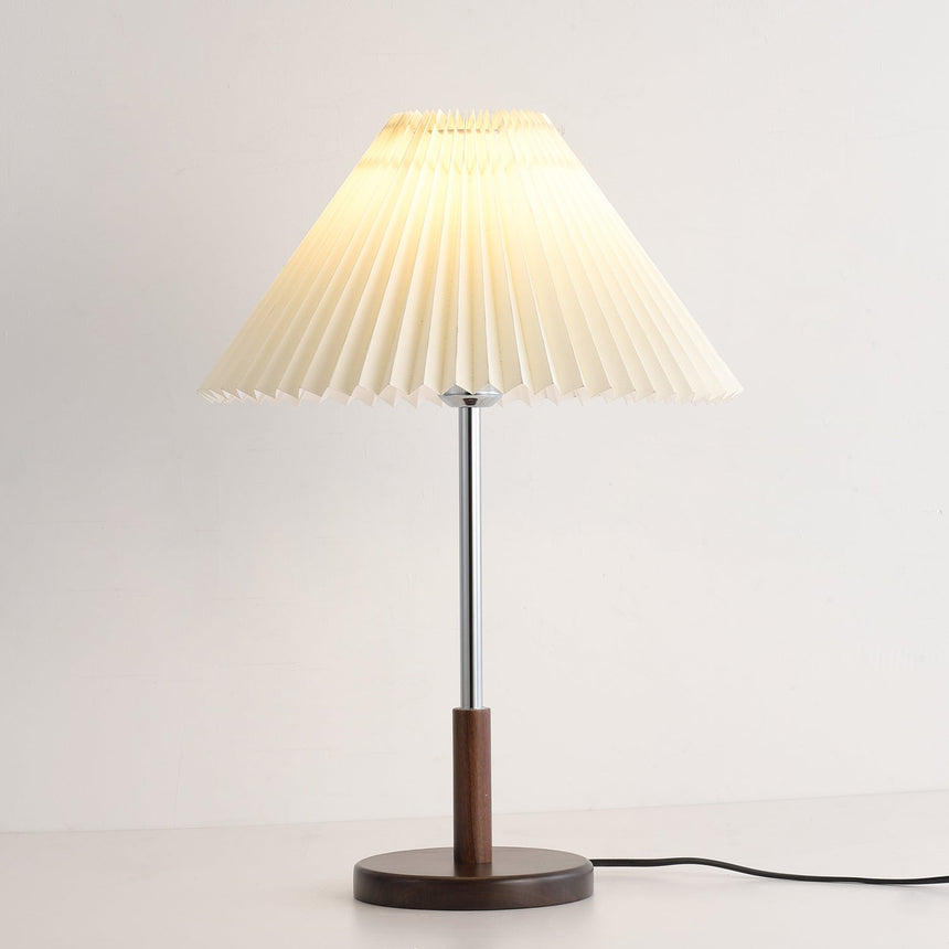 Chrome stem table lamp lit and seen from slightly below the shade line
