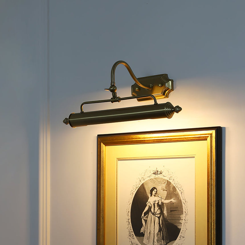 The gold version lit above a gilt framed engraving on a dark blue wall
