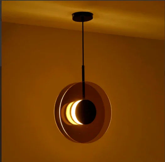 The disc hung upright against a warm lit wall showing its lit edge