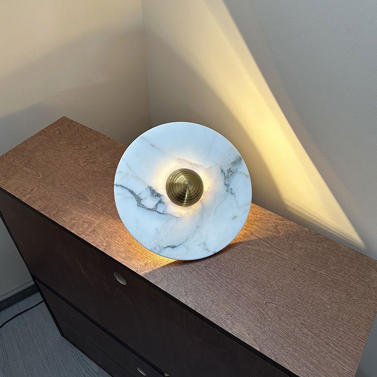 The marble disc with a gold center resting on a cabinet