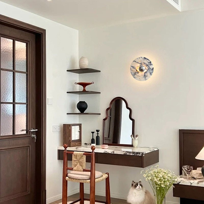 The marble disc lit above a dressing table with a curved mirror