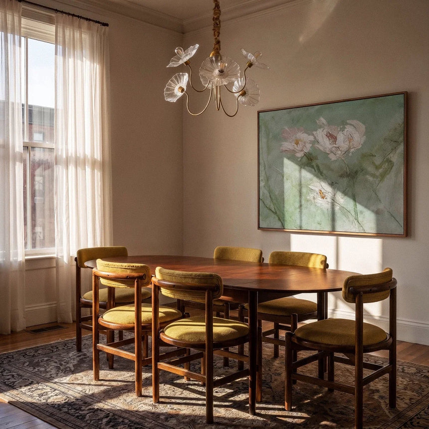 The clear version lit above a dining table with chairs, artwork and a rug
