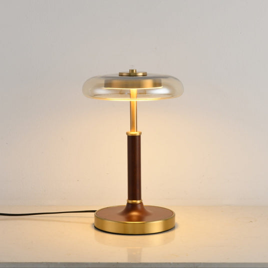 Close view of the round brass foot under the walnut column