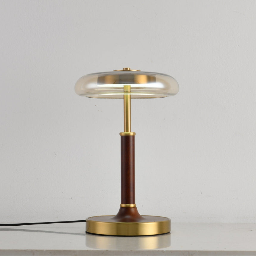 Clear glass disc lamp unlit against a pale gray ground