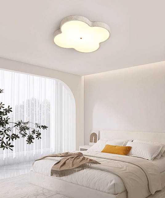 Cloud ceiling lamp in a bedroom with an arched window, a plant and white bedding