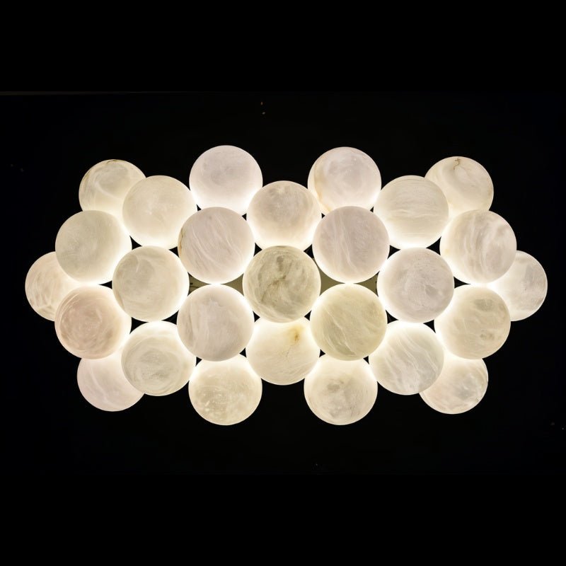 The full raft of lit alabaster globes on a dark ground, two layers deep