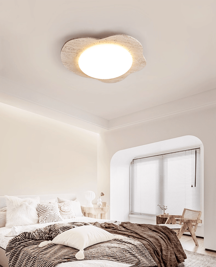 Cloud ceiling light in a bedroom with white bedding, a window seat and a wood chair