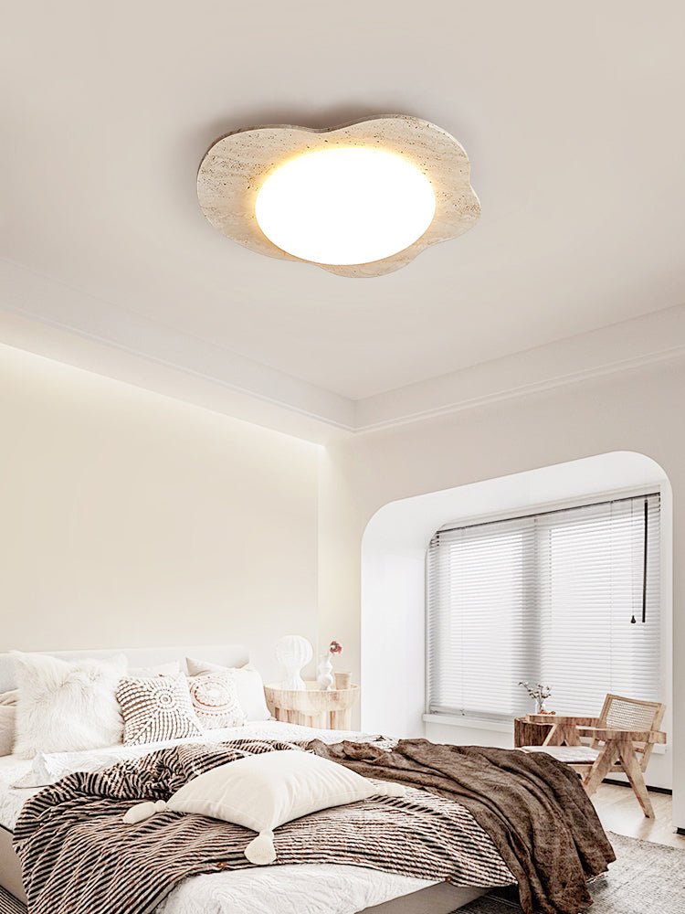 Cloud shaped ceiling fixture above a bed with brown bedding and an arched window