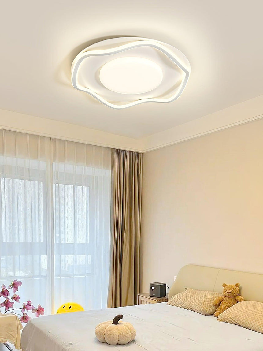 Cloud shaped ceiling lamp lit in a child bedroom with a soft toy on the bed