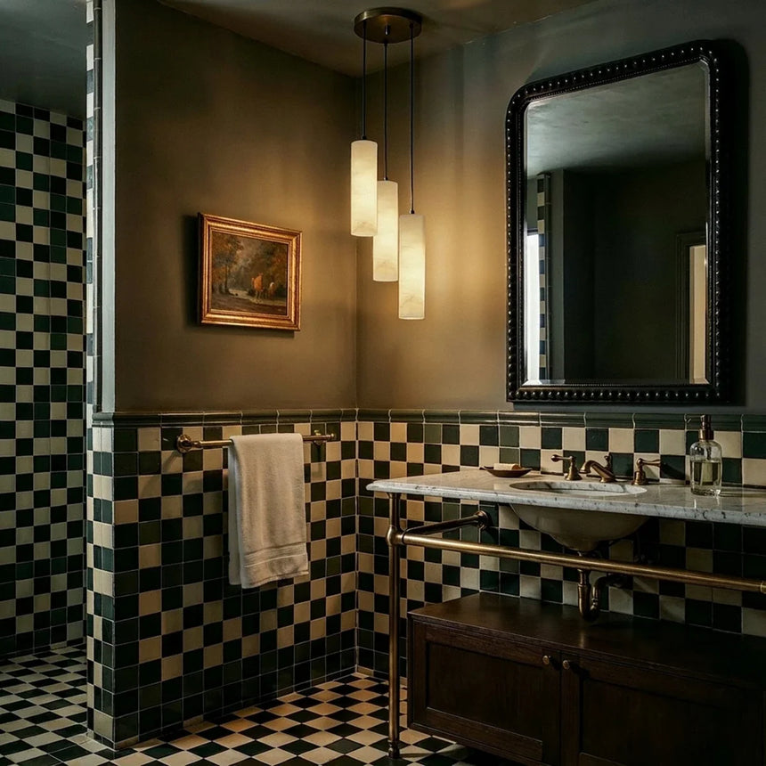 Lit stone cylinders in a green bathroom with a checkerboard floor and a mirror