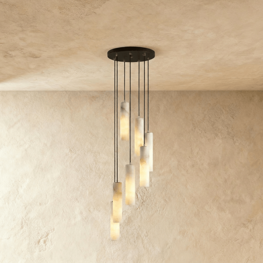 A long drop of lit alabaster cylinders spread down a plaster wall
