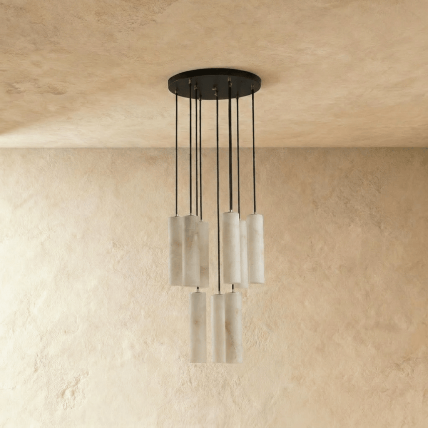 A medium cluster of pale stone cylinders unlit under a round black plate