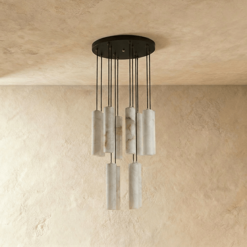 A tall cluster of unlit alabaster cylinders on long black cords