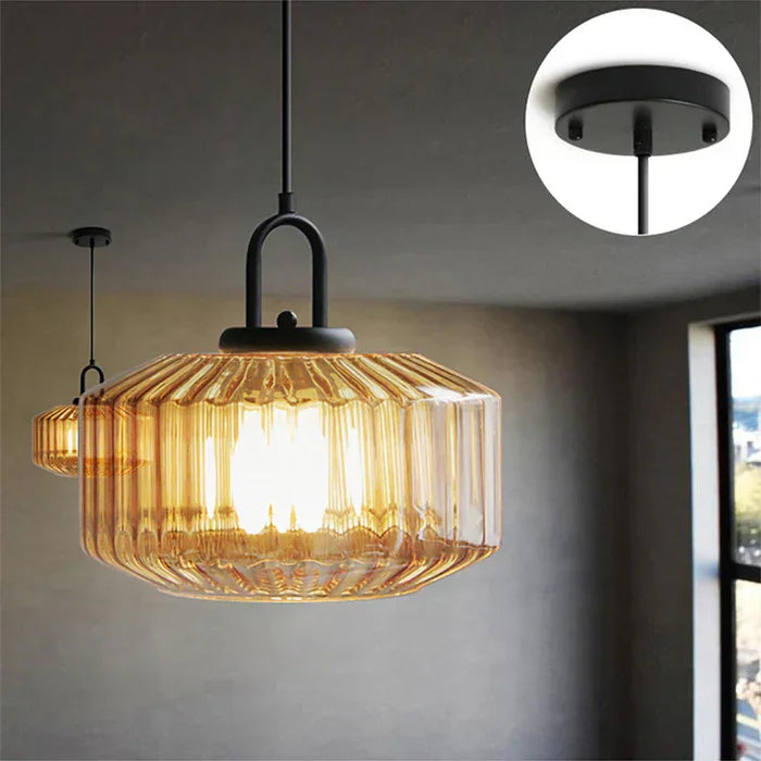 Amber ribbed drum lit above a kitchen counter with a window to the right