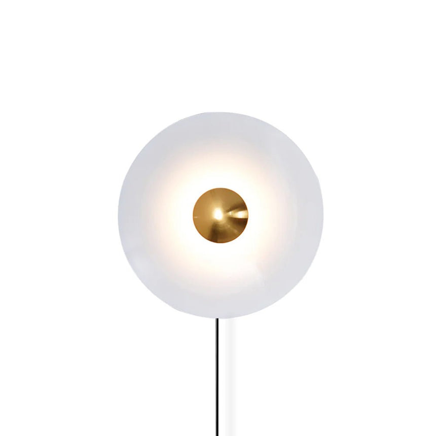 The white disc with a copper tone center and its cord on a white background