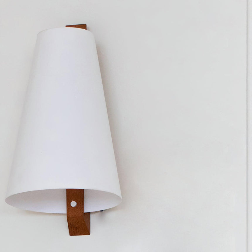 The leather tab that fastens the parchment shade to the wood bracket