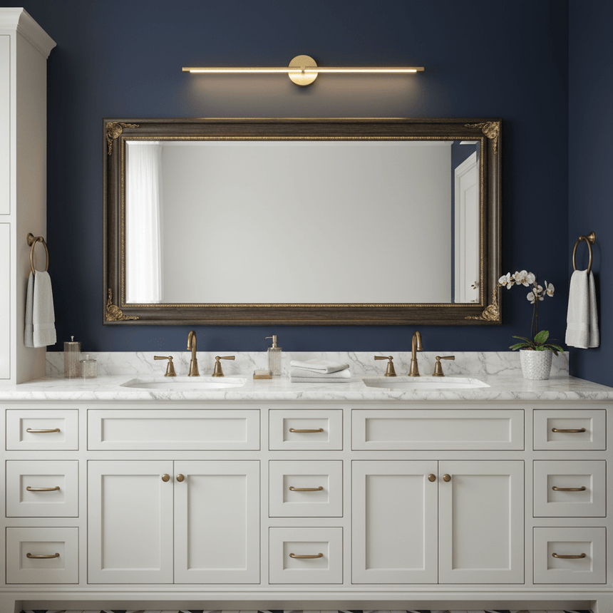 Gold rod lit above a wide mirror over a white double vanity with two basins