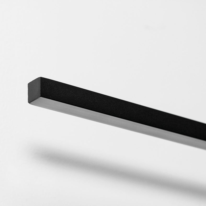 Close view of the square black profile of the bar against a pale wall
