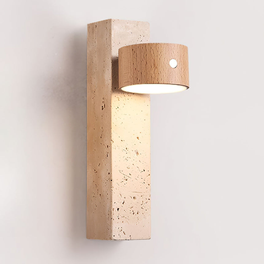 Travertine wall sconce lit, the light wood head turned down toward the wall