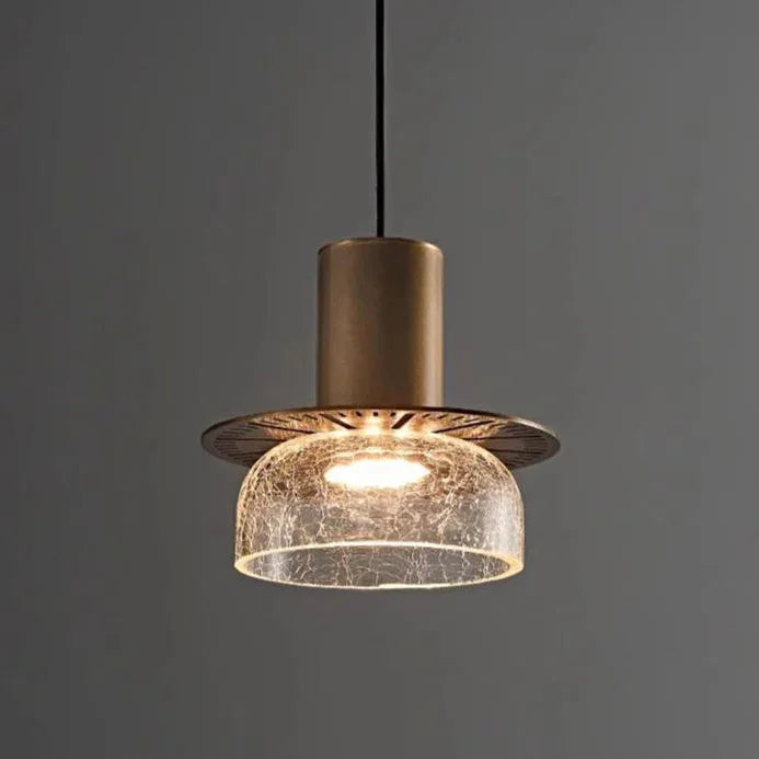 An amber crackle shade under a brass cap lit against a dark background